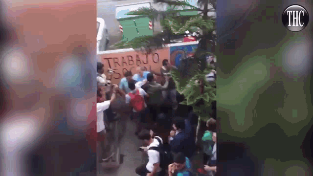 a group of people are gathered in front of a wall that says trabajo