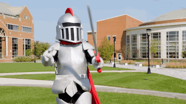 a knight mascot is holding a sword in front of a building