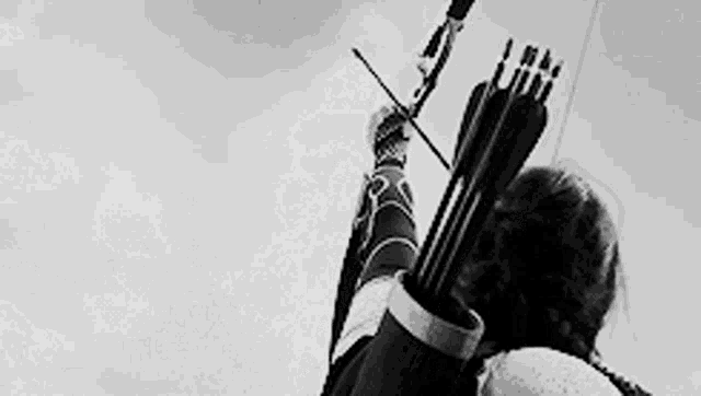 a person is holding a bow and arrow in their hand .