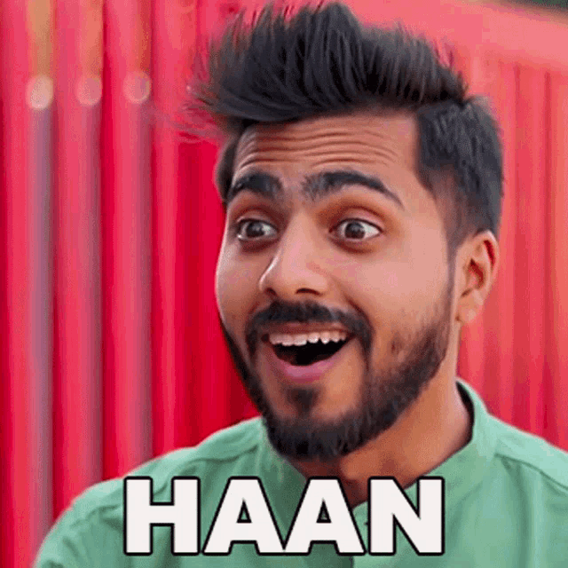 a man with a beard is making a funny face and the word haan is on his shirt