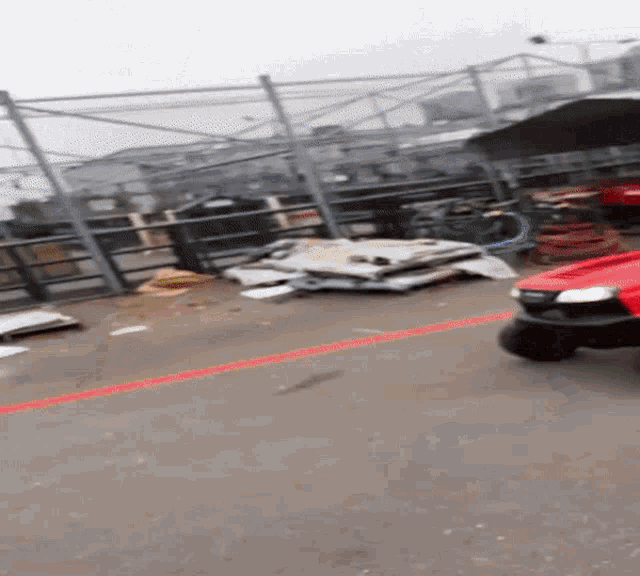 a red vehicle is parked in a parking lot with a red line on the ground
