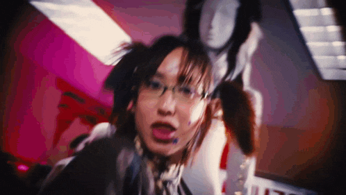 a woman with pigtails and glasses is standing in a room