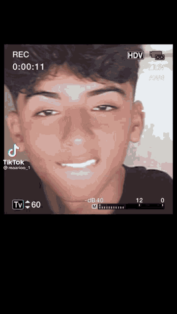 a tiktok video of a young man is being recorded on a tv