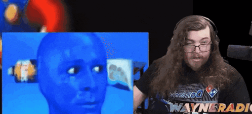 a man with long hair and glasses is wearing a domino 's shirt .