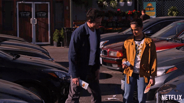 a man and a woman are standing in front of a co-op