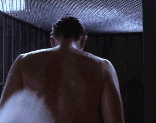 a man without a shirt is taking a shower