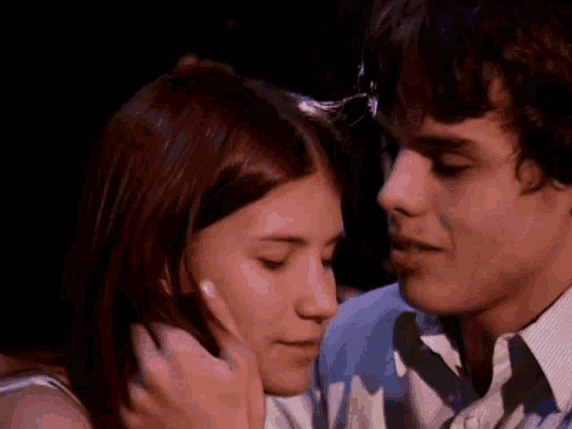 a man and a woman are hugging each other and kissing .
