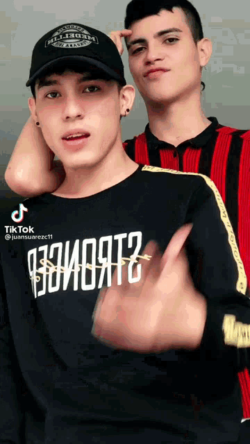 two young men are standing next to each other and one of them is wearing a shirt that says juansuarez11 on it