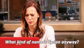 a woman is sitting in front of a red laptop and asking what kind of name is tyrion anyway