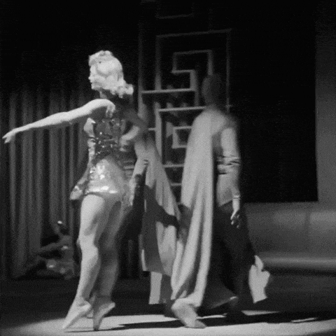 a black and white photo of a man and a woman dancing on a stage