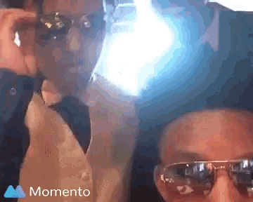 two people wearing sunglasses and a momento icon