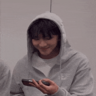 a man wearing a grey hoodie with the word supreme on the front