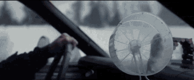 a person is driving a car with a fan on the dash