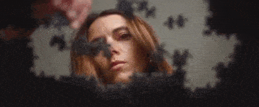 a close up of a woman 's face surrounded by jigsaw puzzle pieces .