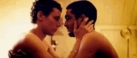 a couple of men are hugging each other in a room .