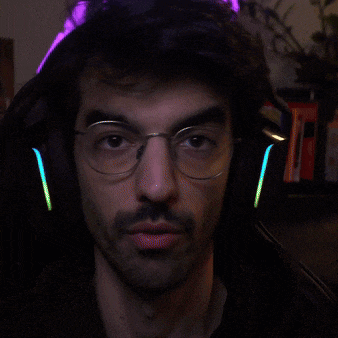 a man with glasses and headphones looks at the camera