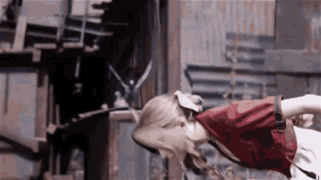 a woman in a red shirt is doing a handstand in front of a wall .
