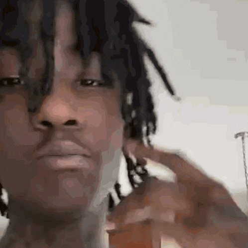 a close up of a man 's face with dreadlocks covering his ear .