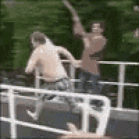 a couple of men are standing next to each other on a bridge .