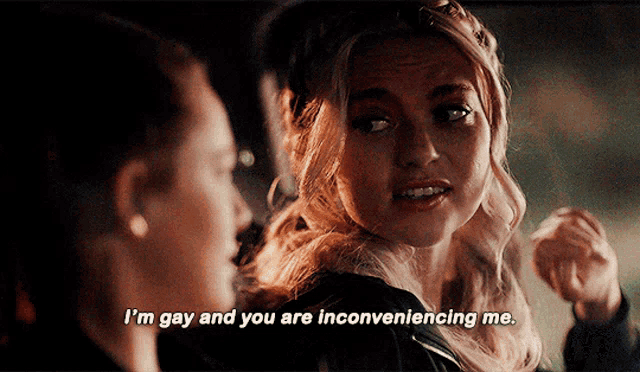 two women are talking and one says i 'm gay and you are inconveniencing me