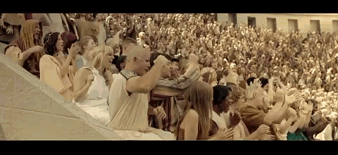 a crowd of people are sitting in a stadium watching a sporting event