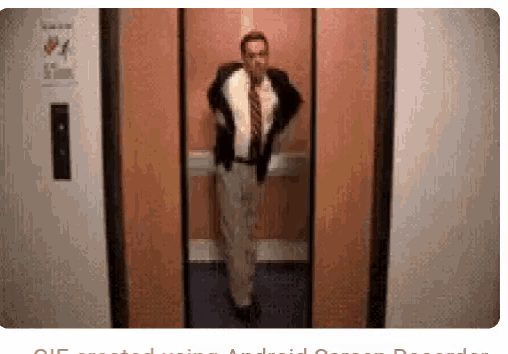 a man in a suit is standing in an elevator .