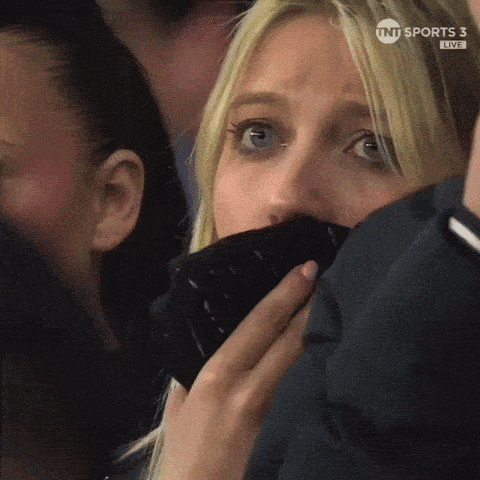 a woman covering her mouth while watching a game on tnt sports 3