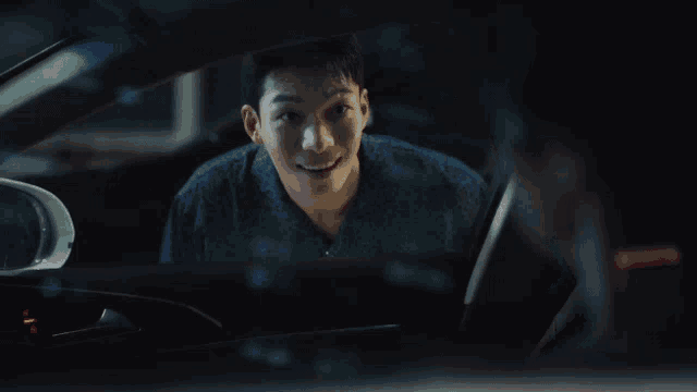 a man is sitting in a car and smiling