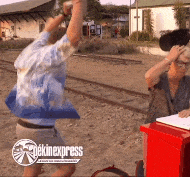 a man and a woman are standing in front of a red box that says pekineexpress