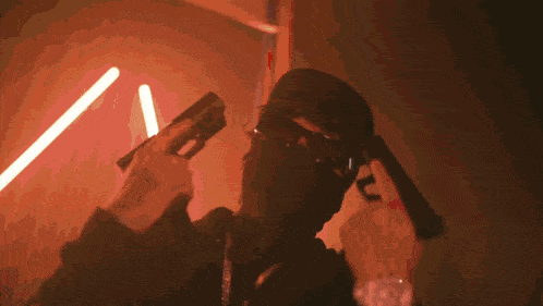 a man wearing a mask is holding a gun in his hand