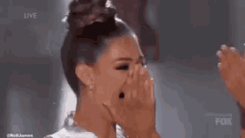 a woman in a dress is covering her face with her hands .