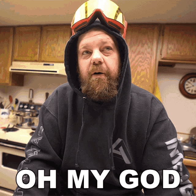 a man with a beard wearing a hoodie and goggles says oh my god in white letters