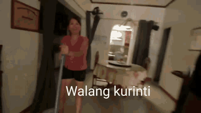 a woman in a pink shirt is holding a mop in a room with the words walang kurinti on the bottom right