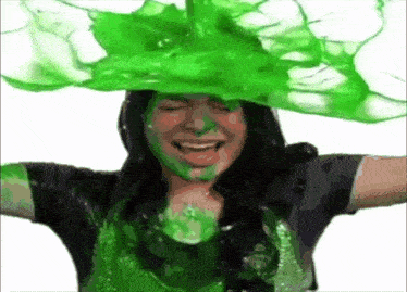 a woman is covered in green slime and laughing