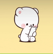 a white teddy bear is holding a cell phone in its hands .
