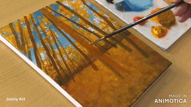 a painting of trees is being painted on a canvas by joony art
