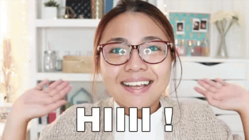 a woman wearing glasses and a sweater is smiling and says hhh