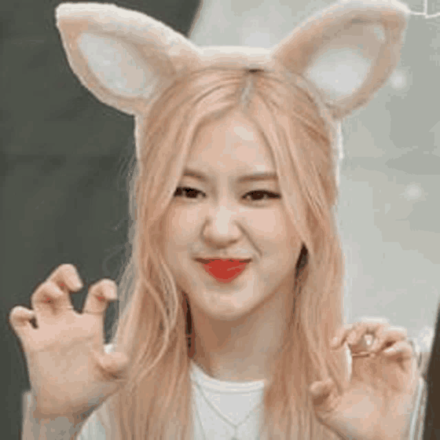 a close up of a woman wearing a headband with bunny ears on her head .
