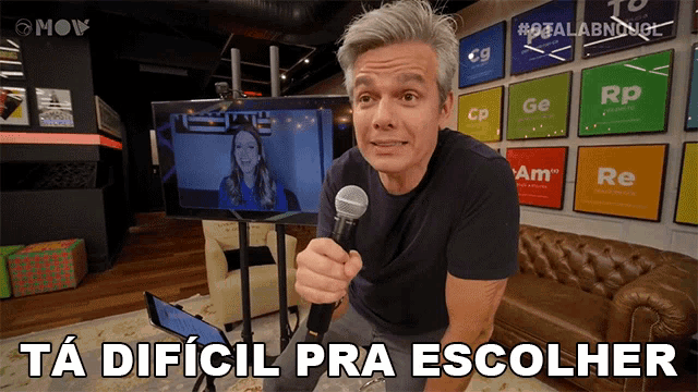 a man holding a microphone with the words ta dificil pra escolher written below him