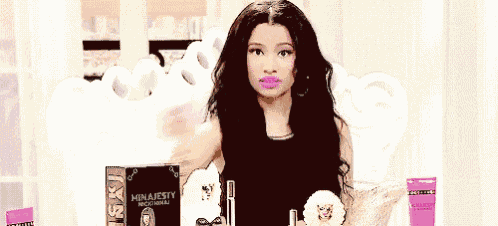 a woman in a black shirt is holding a bottle of perfume and says okay .