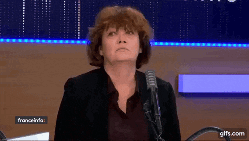 a woman is standing in front of a microphone with franceinfo written in the corner