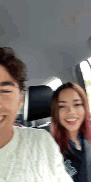 a man and a woman are in a car and smiling