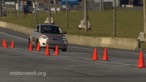 a car is driving down a road with orange cones on the side of it