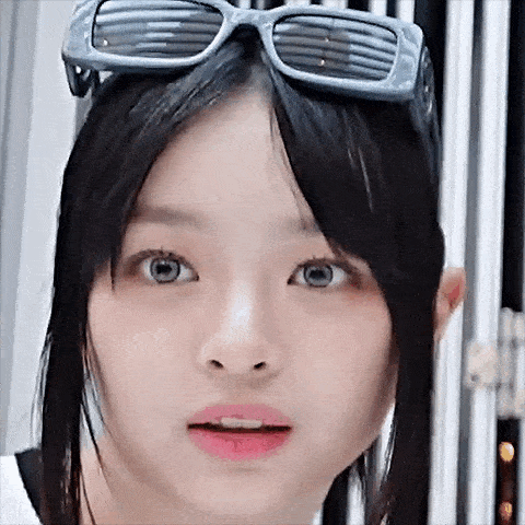 a close up of a young woman wearing sunglasses and making a funny face .