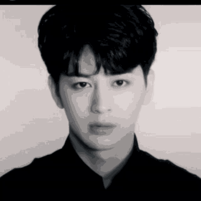 a black and white photo of a young man 's face .