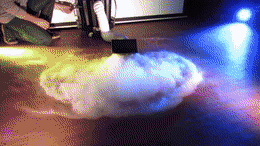 a person is kneeling down in front of a cloud of smoke coming out of a pipe