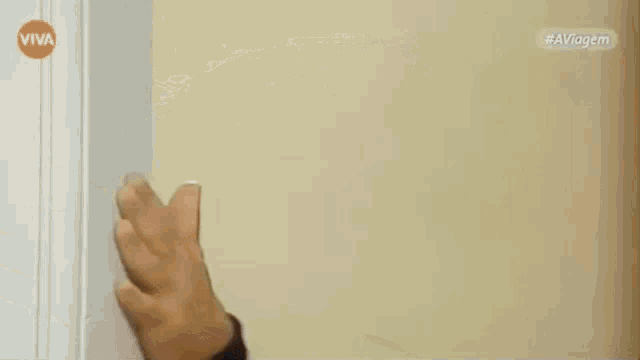 a man with blonde hair is peeking out from behind a door with the word viva in the corner