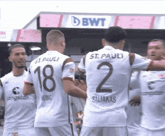 a group of soccer players are standing in front of a bwt banner