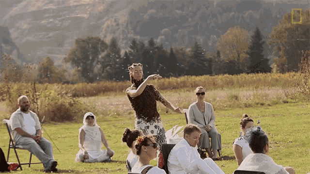 a group of people are gathered in a field with a national geographic logo on the bottom right