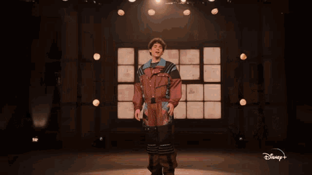 a man is standing on a stage in front of a sign that says auditions